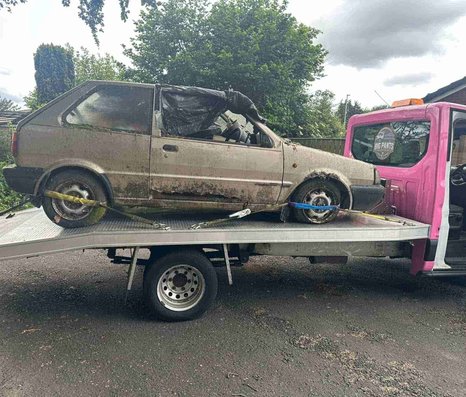 Scrapped car being taken away