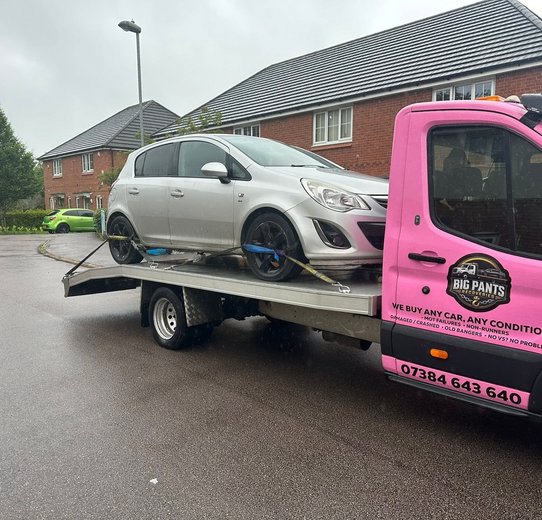 Silver Hatchback loaded on pink truck