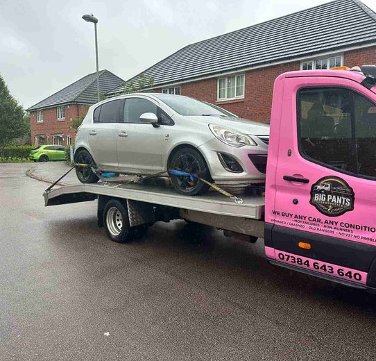 Silver Hatchback loaded on pink truck